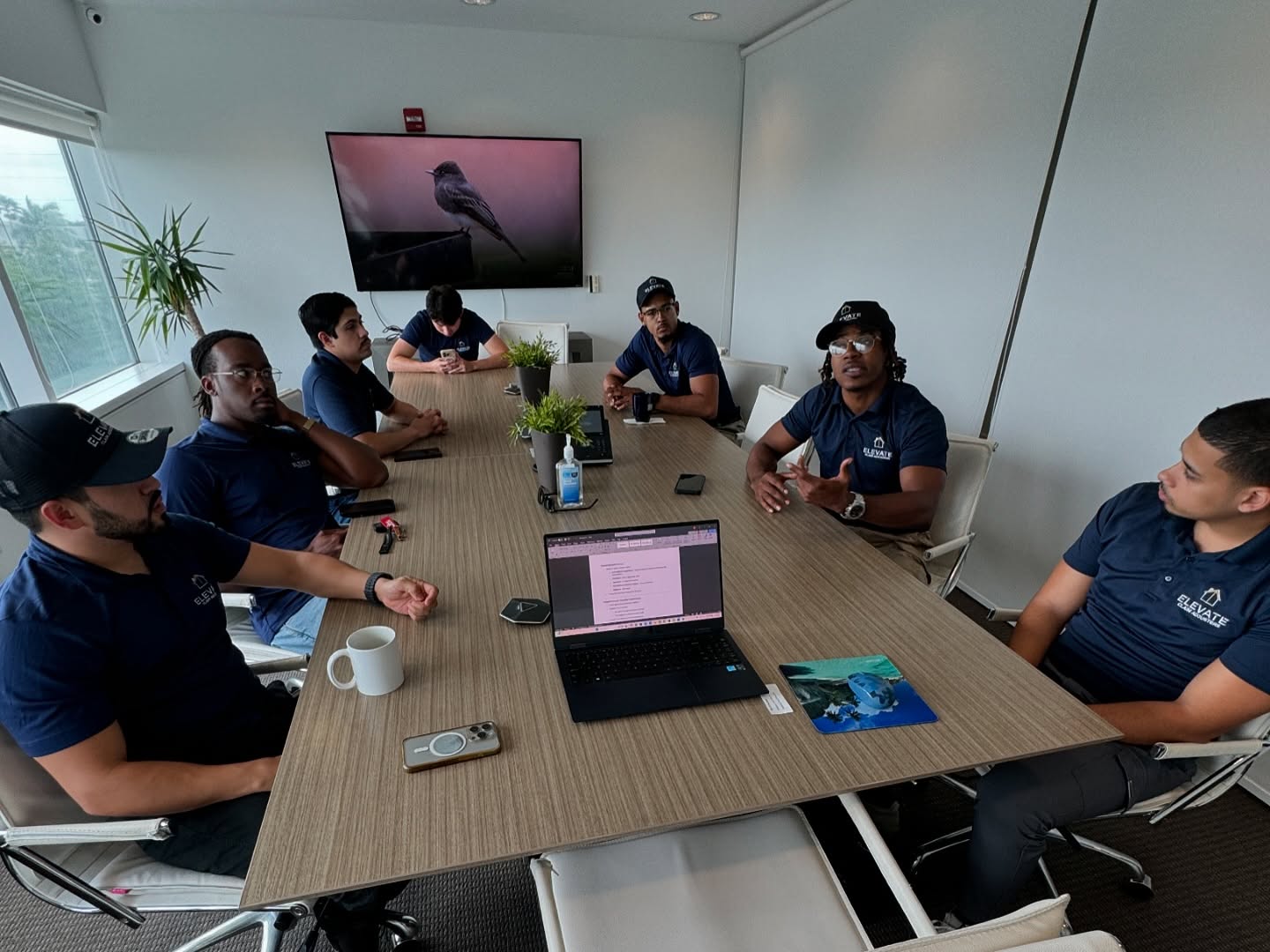 Elevate Claim Adjusters team collaborating in an office meeting to strategize insurance claim support for clients
